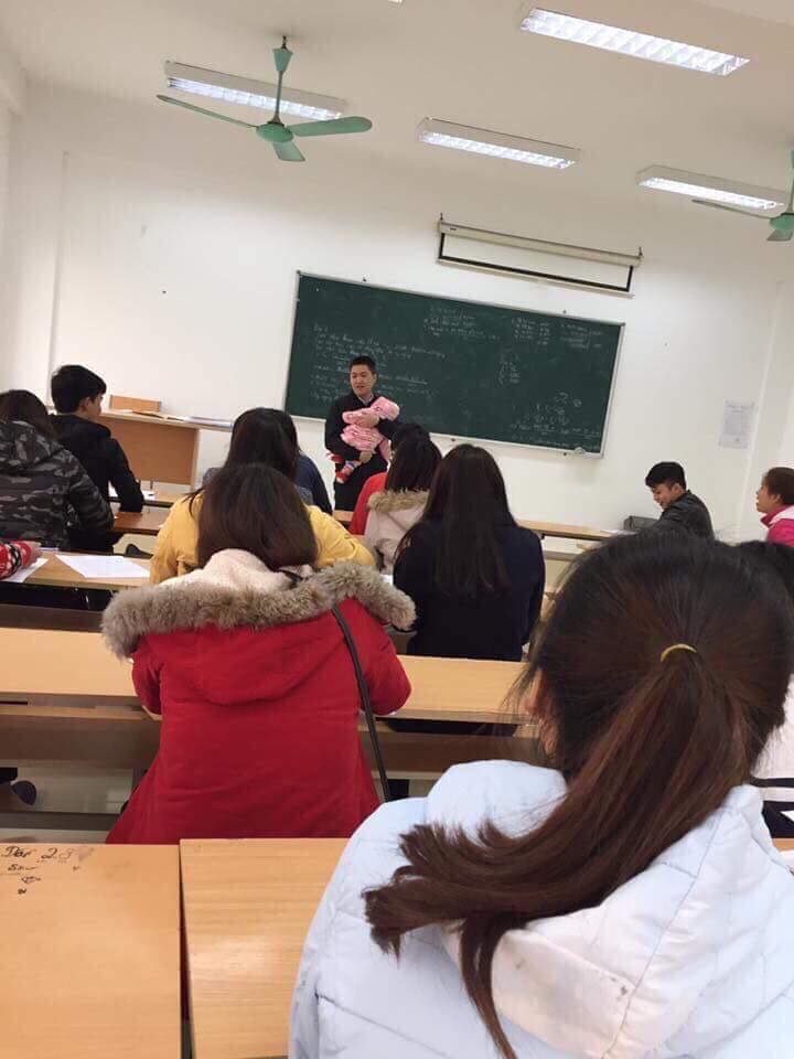 Thầy giáo bế con cho sinh viên làm bài thi