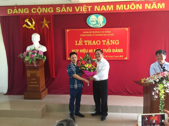 Đại diện Ban Giám hiệu, TS. Nguyễn Xuân Sang - Hiệu trưởng Nhà trường tặng hoa chúc mừng đ/c Nguyễn Văn Phong